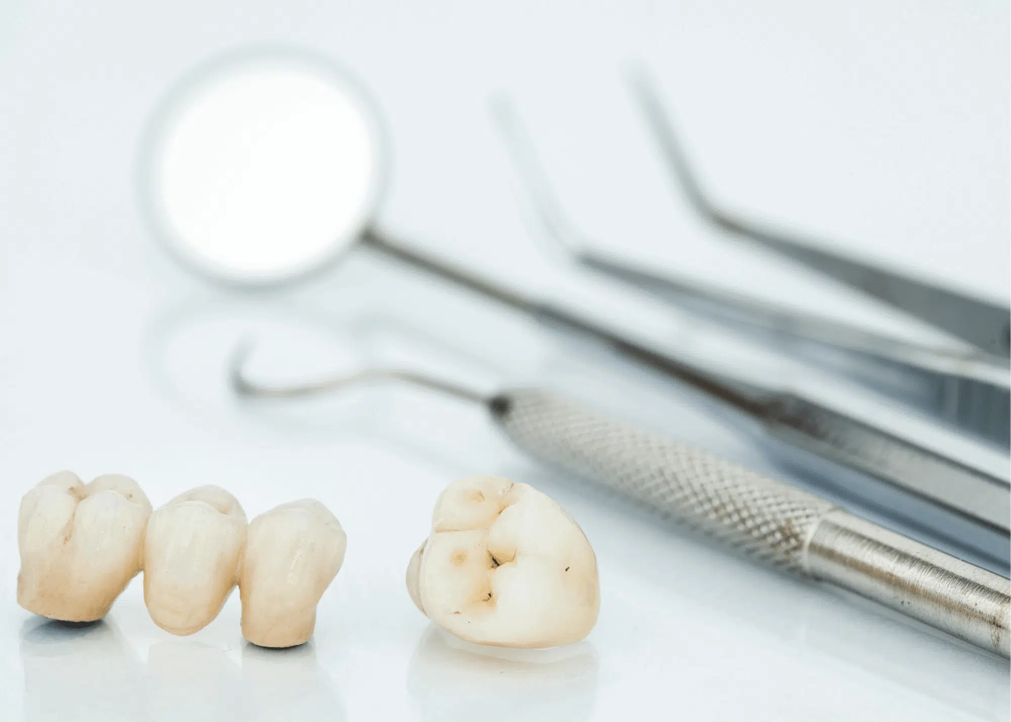 Several dental crowns placed next to dental tools on a clean surface, ready for dental procedures. Several dental crowns placed next to dental tools on a clean surface, ready for dental procedures.